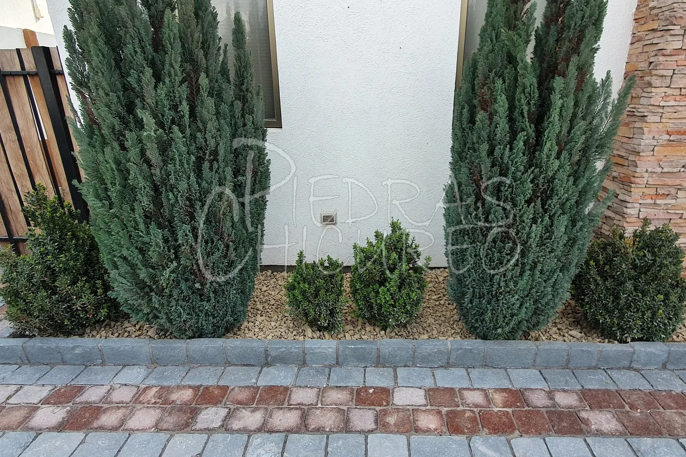 Fachada de casa con piedra amarilla decorativa y adoquines en entrada — foto C